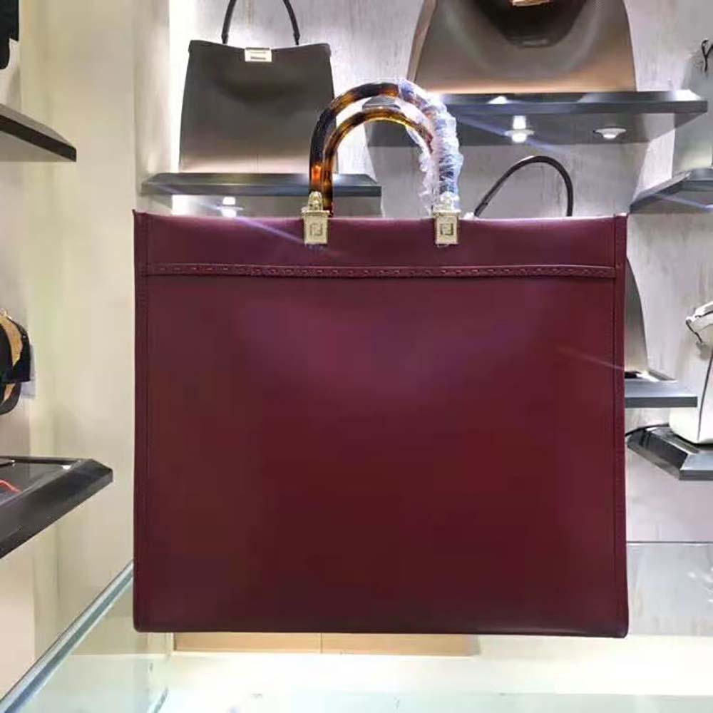 Side angle showing the spacious silhouette of Fendi Women Sunshine Shopper Burgundy Leather Shopper-Maroon