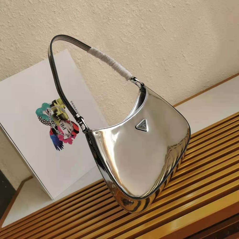 Close-up on silver triangular Prada plaque and brushed leather texture