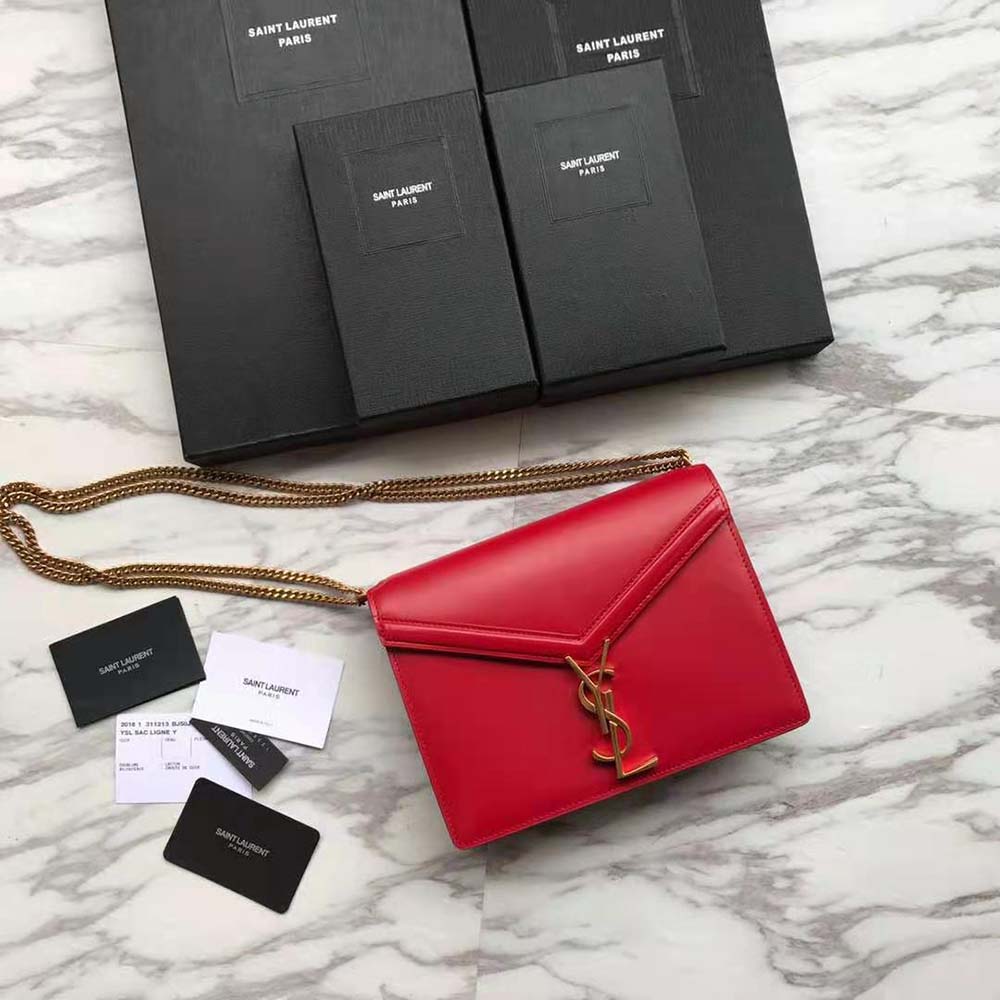 Close-up of gold YSL monogram clasp on red Cassandra embossed leather bag