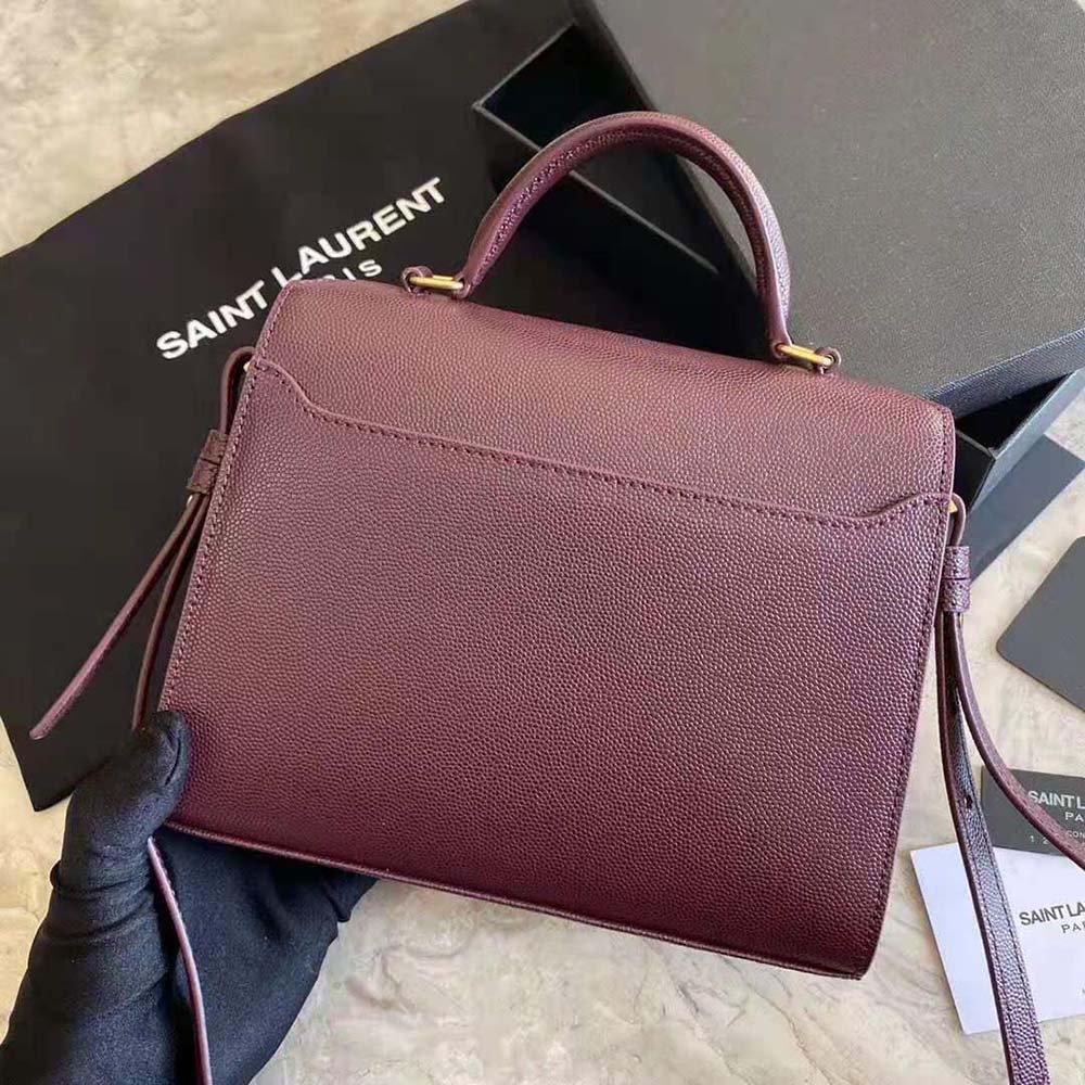 Side angle showing structured silhouette of Cassandra Top Handle Medium Bag maroon
