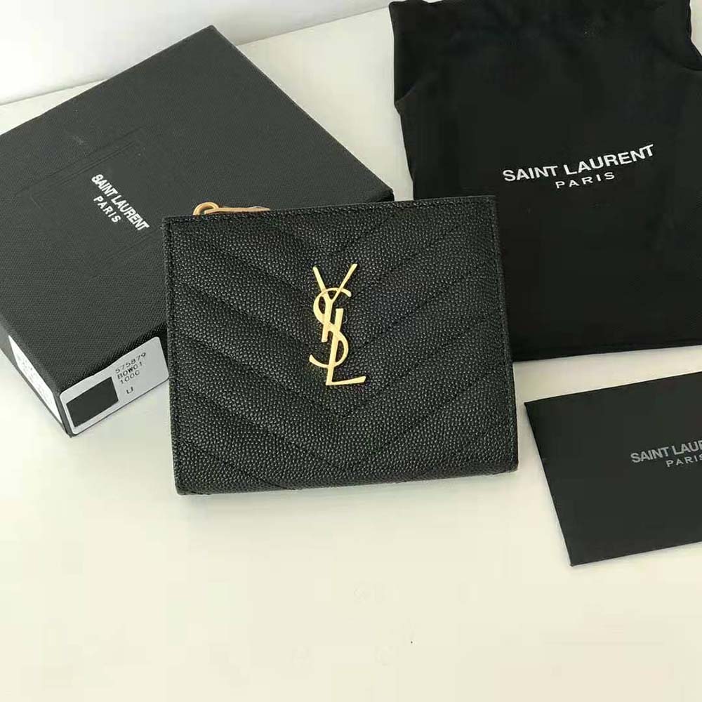 Close-up of gold YSL monogram on zipped card case black leather