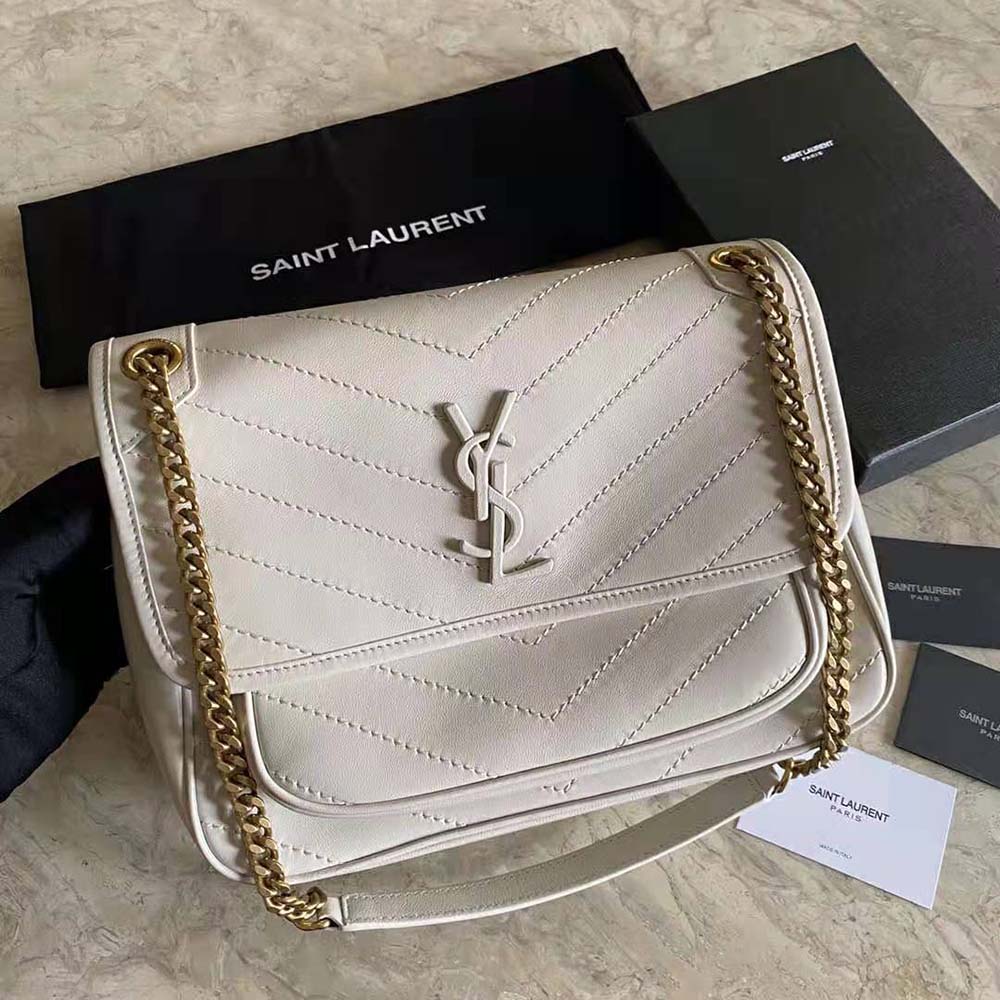 Close-up of gold YSL signature hardware on white Niki medium bag