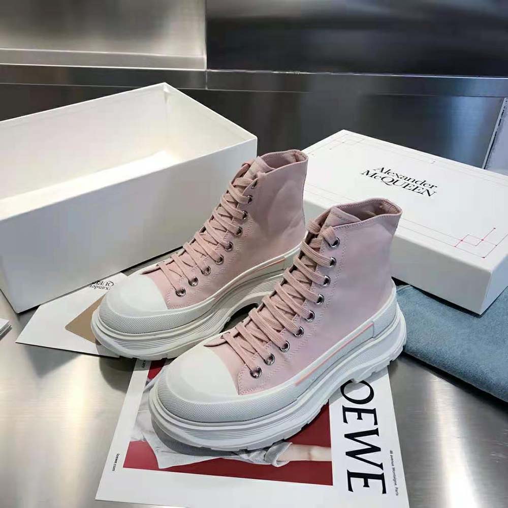 Close-up on chunky tread sole and embossed logo of pink Alexander Mcqueen boot