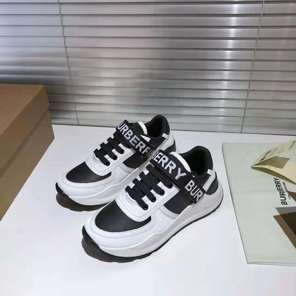 Close-up of Burberry logo detail on black leather sneaker