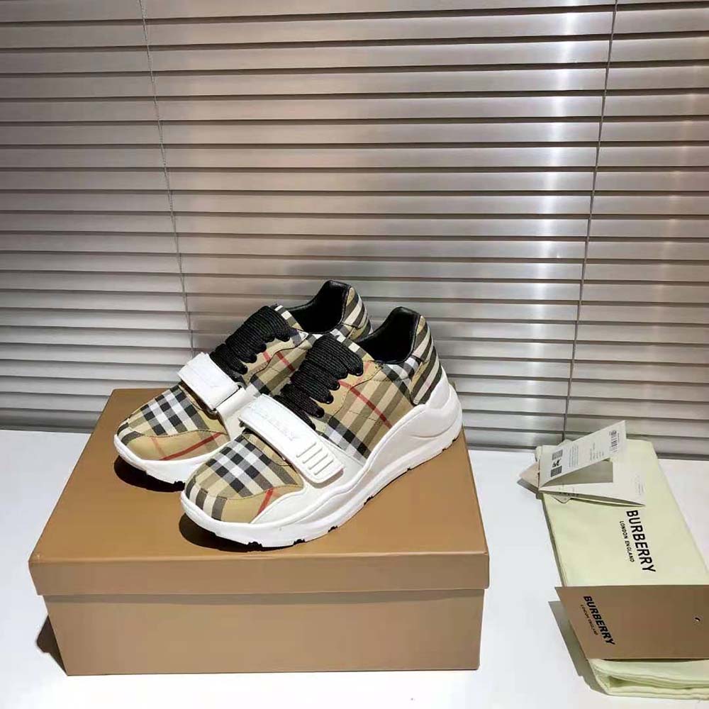 Close-up of lace-up and signature Burberry check on brown sneakers