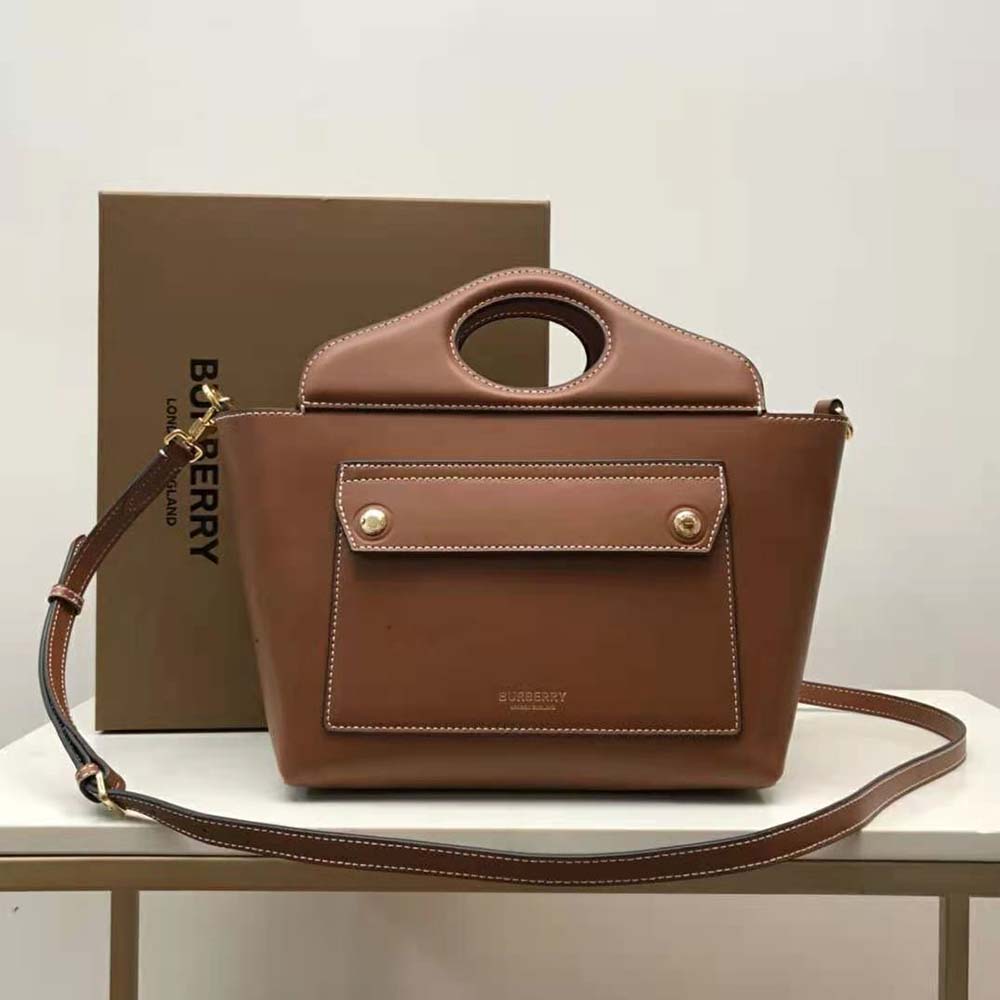 Close-up of gold-tone hardware on Burberry Women Mini Leather Soft Pocket Tote-Brown
