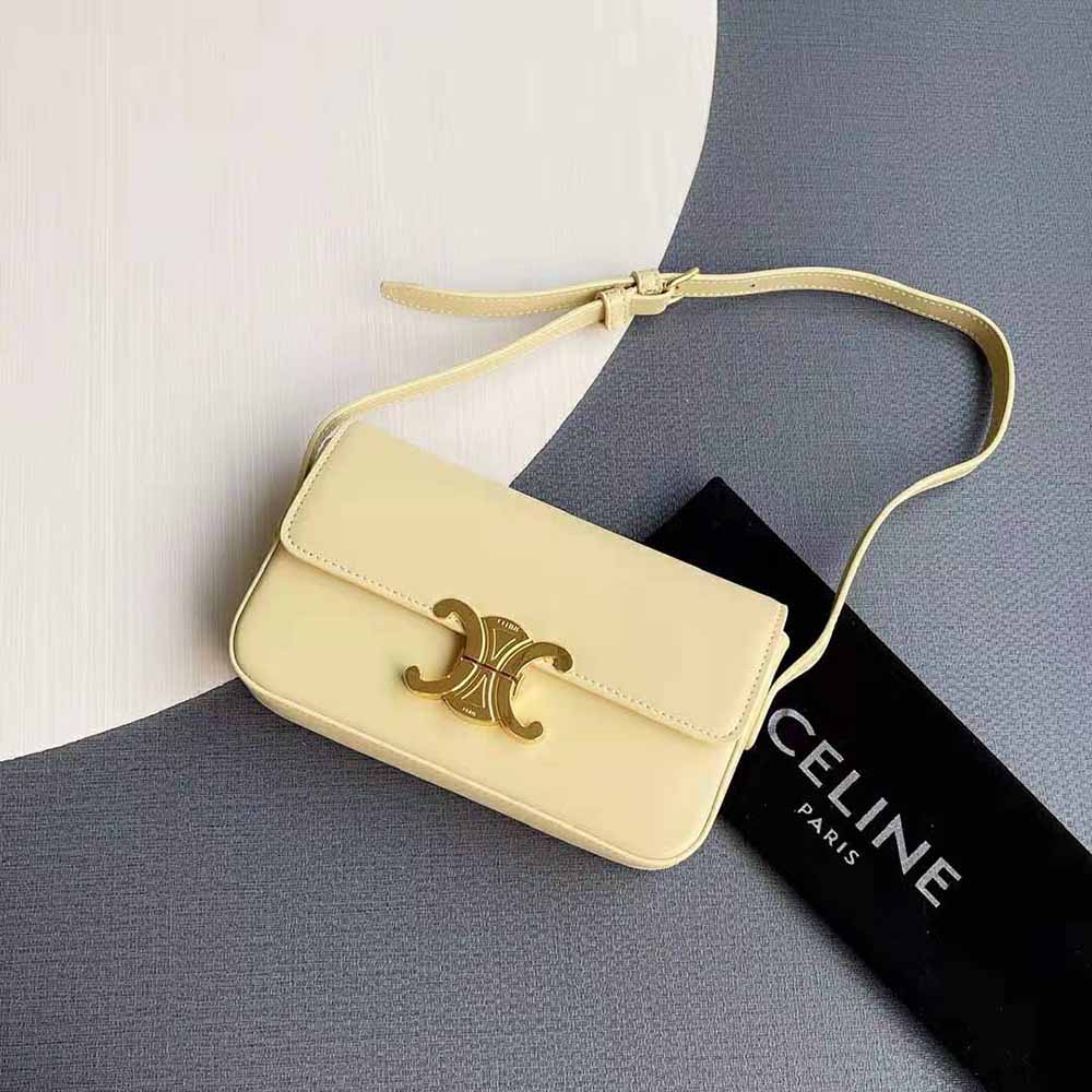 Close-up of gold Triomphe clasp on yellow calfskin shoulder bag