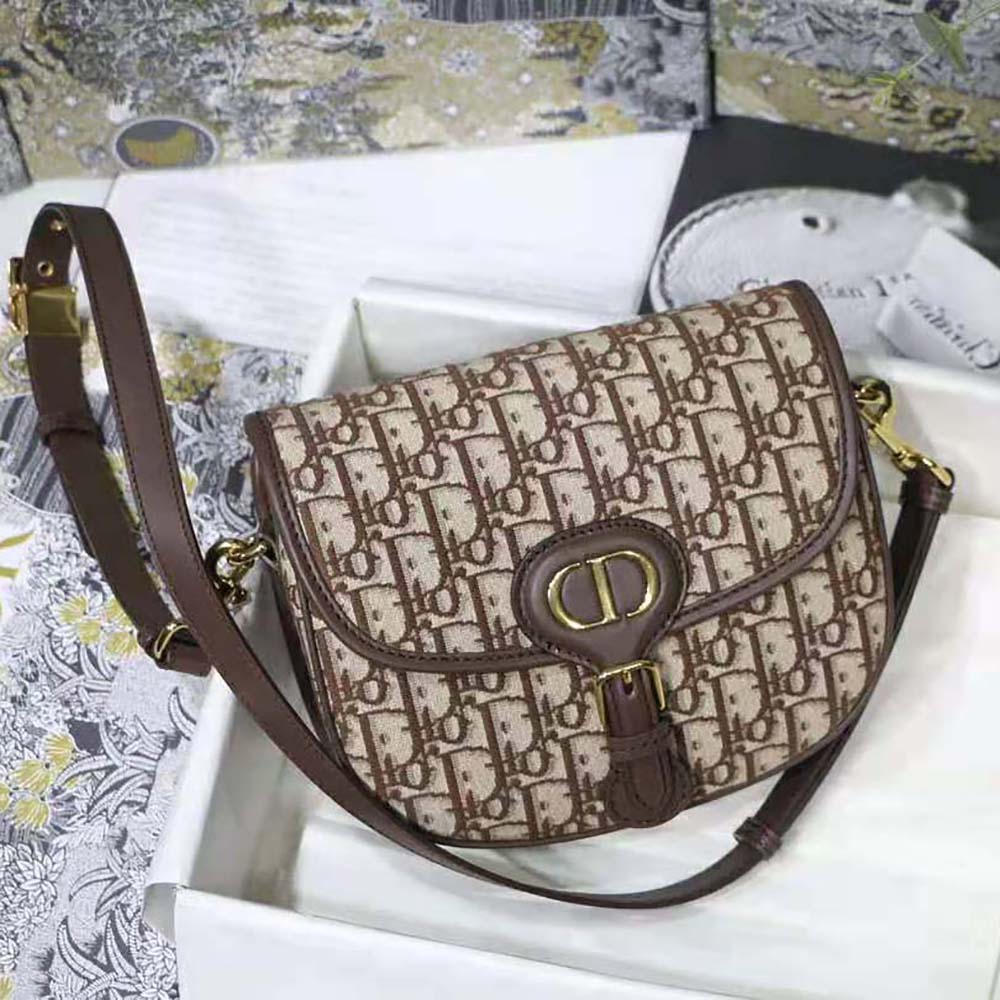 Close-up of brass-tone 'CD' hardware on Dior Women Medium Dior Bobby Bag