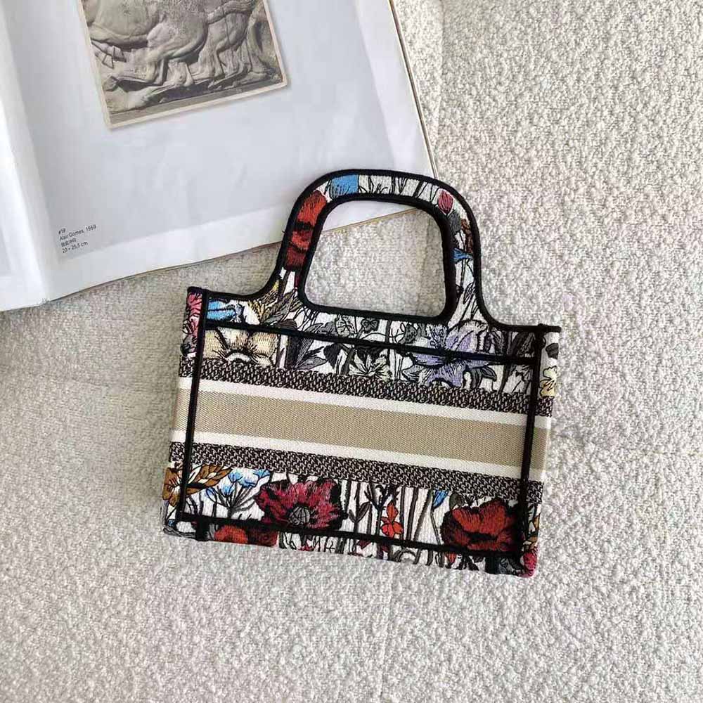 Side angle showing red canvas and gold hardware of Mini Dior Book Tote