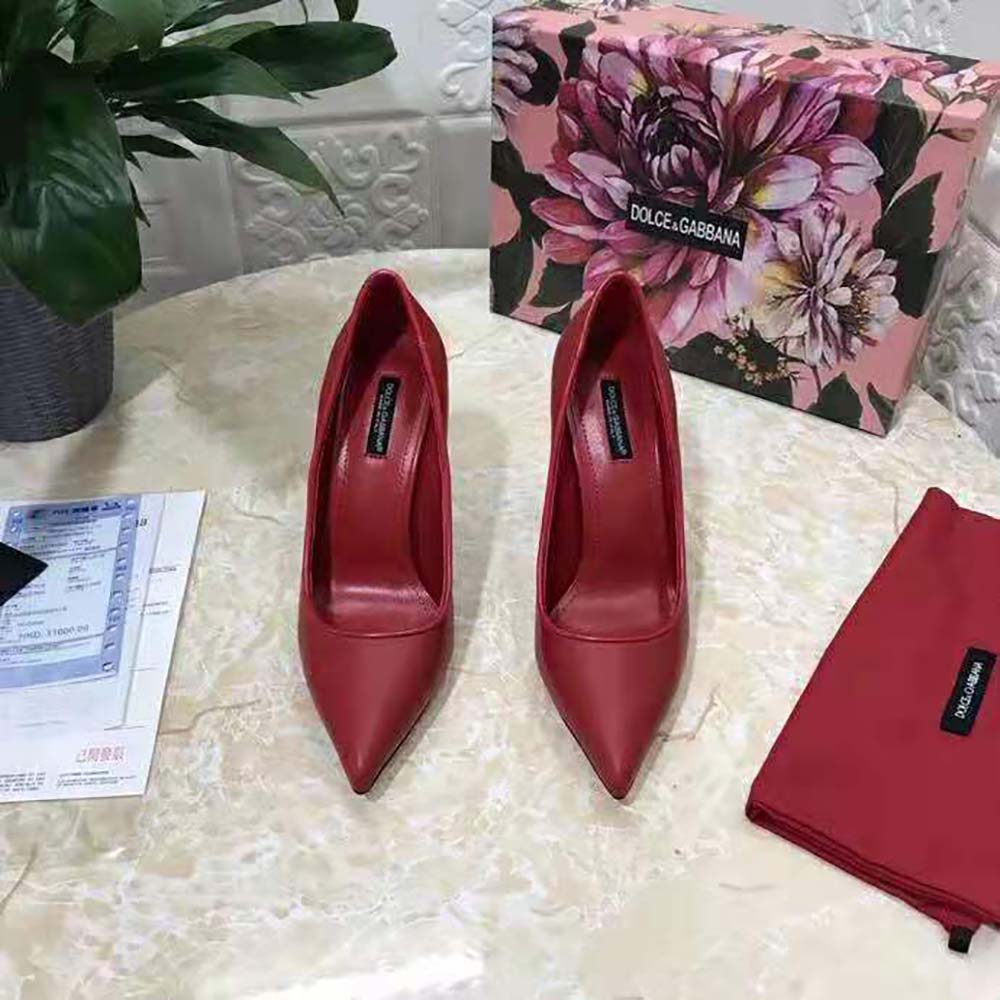 Close-up on gold DG logo hardware on red pumps heel by Dolce Gabbana D&G