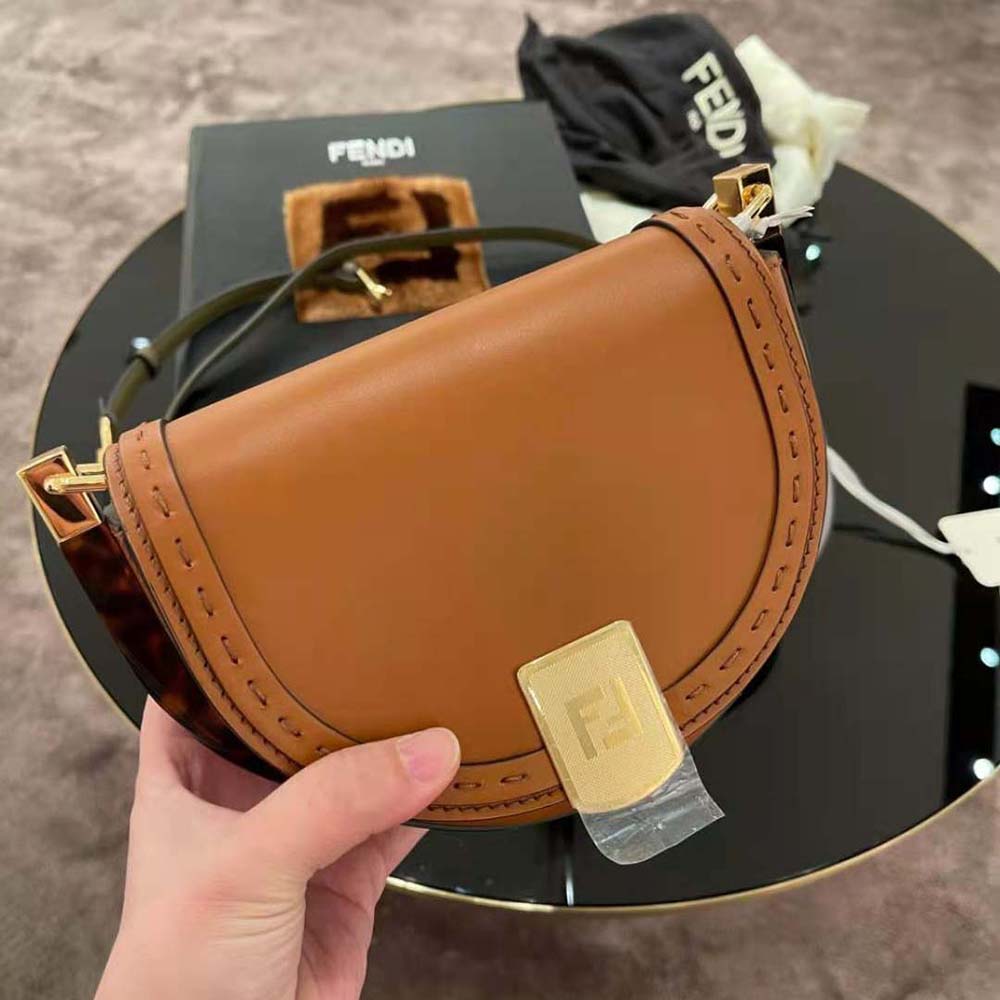 Close-up on hand-stitched leather detail of Fendi satchel bag