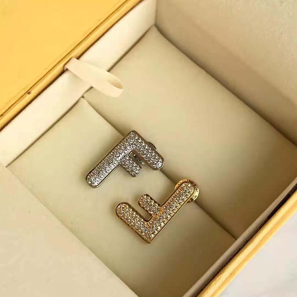 Close-up of polished gold-tone Fendi Women Small FF Earrings surface and clasp