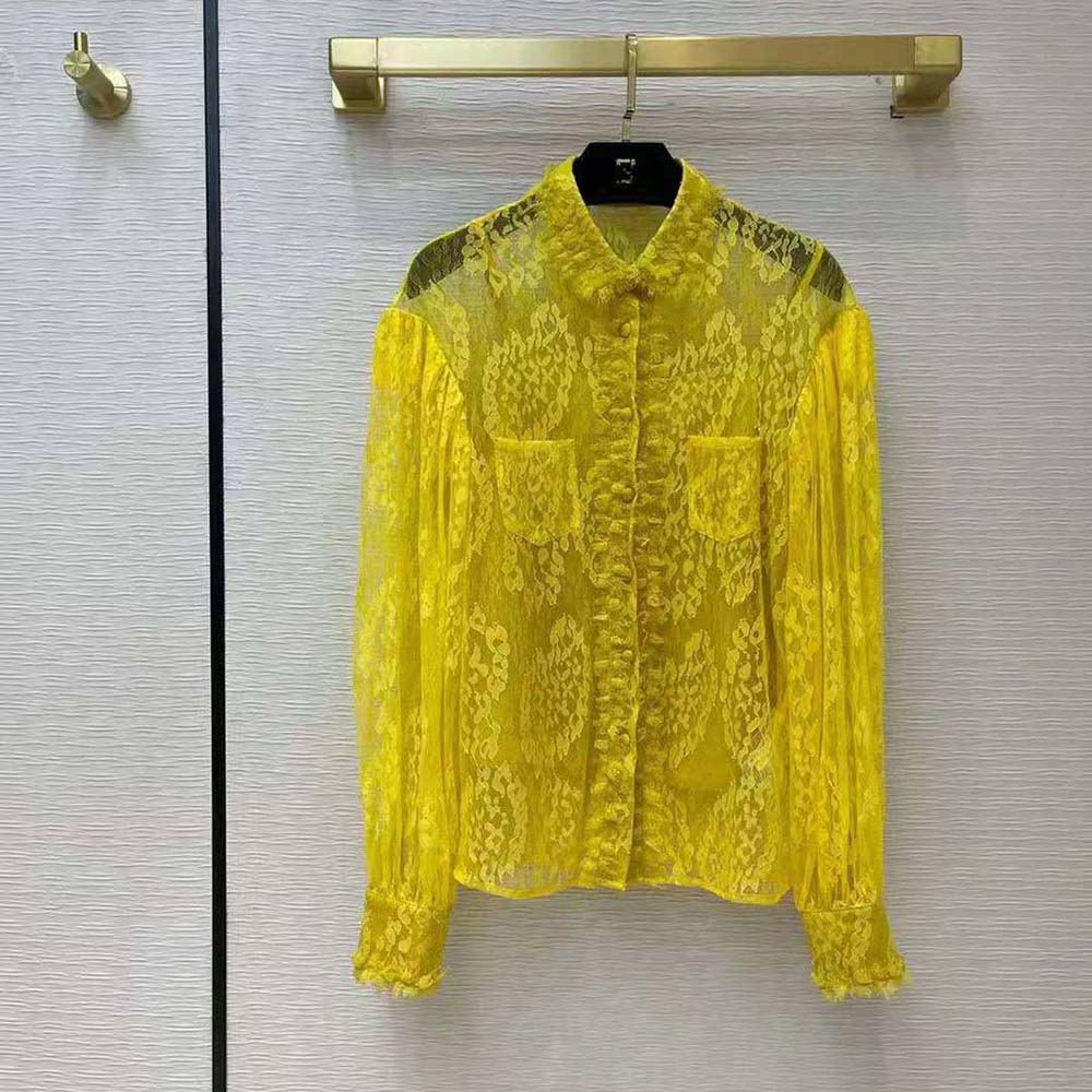 Close-up detail of yellow lace fabric and puff sleeve on Fendi shirt