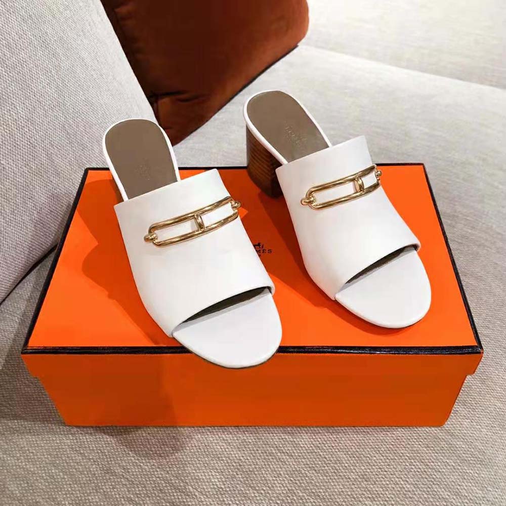 Close-up of white calfskin leather and Hermes embossed detail mule