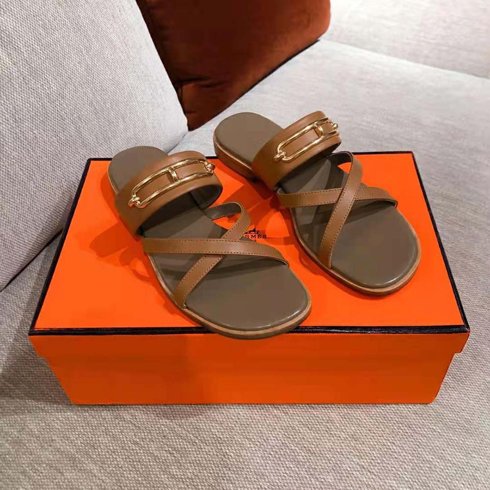 Close-up of signature Hermes hardware on Claire Sandal in brown