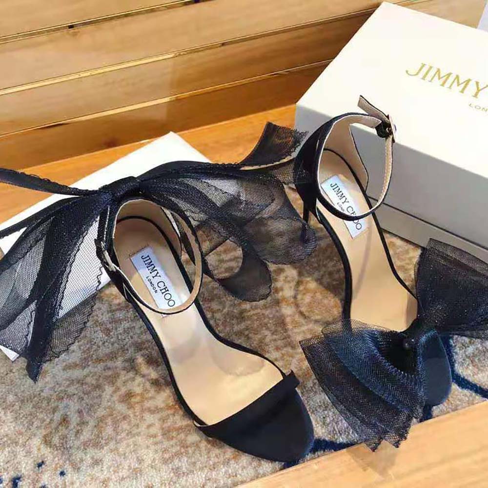 Close-up detail of asymmetric grosgrain mesh bows on Jimmy Choo Aveline sandals