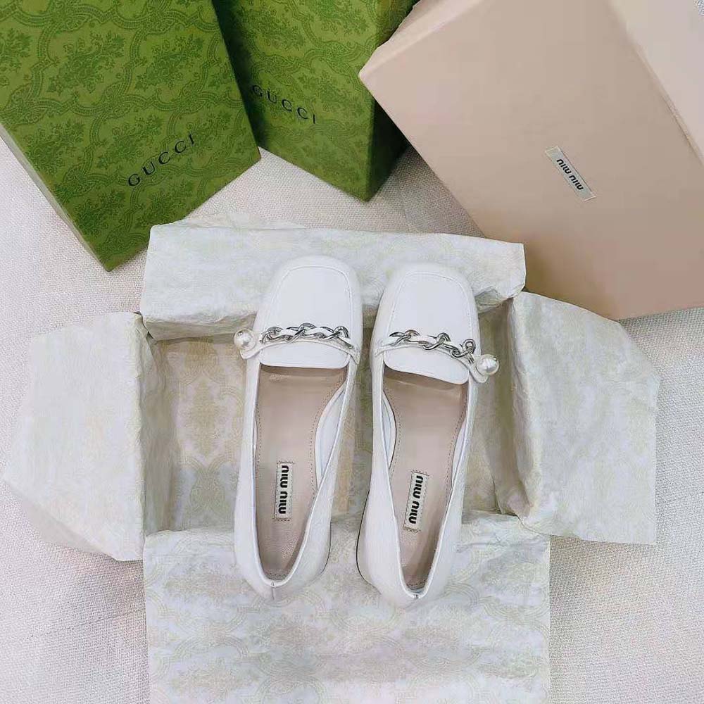 Top detail showing slip-on design of Miu Miu White patent loafers