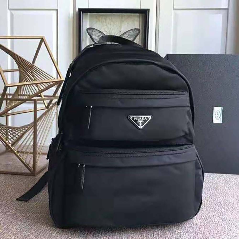 Close-up of signature Prada metal logo on nylon backpack