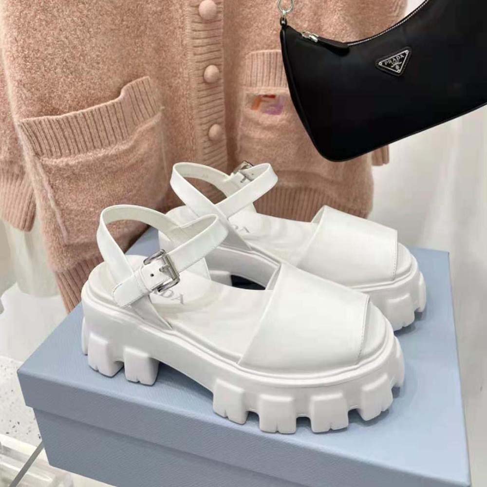Close-up of brushed leather texture and Prada logo on white sandals