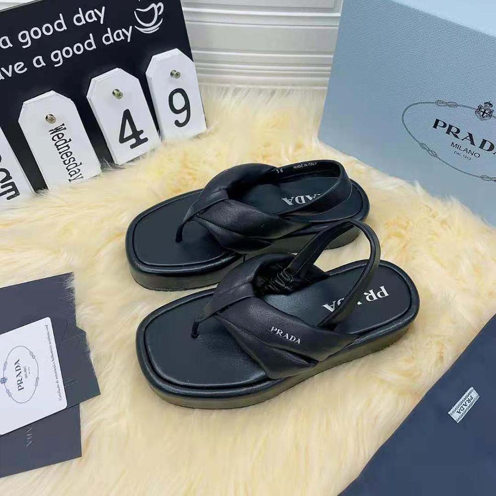 Close-up of black nappa leather and Prada embossed detail on sandals
