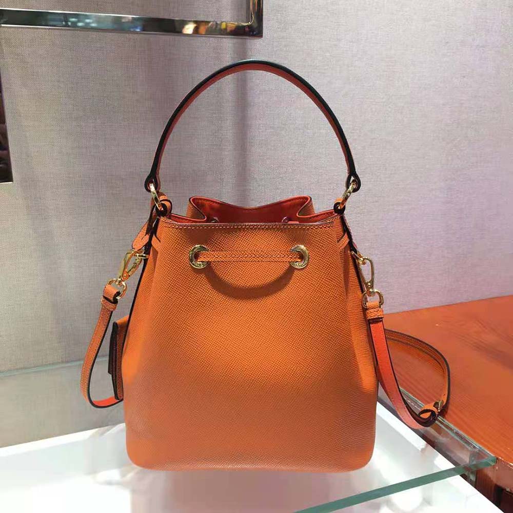 Side angle showing adjustable shoulder strap of Prada Women Saffiano Leather Bucket Bag-Orange