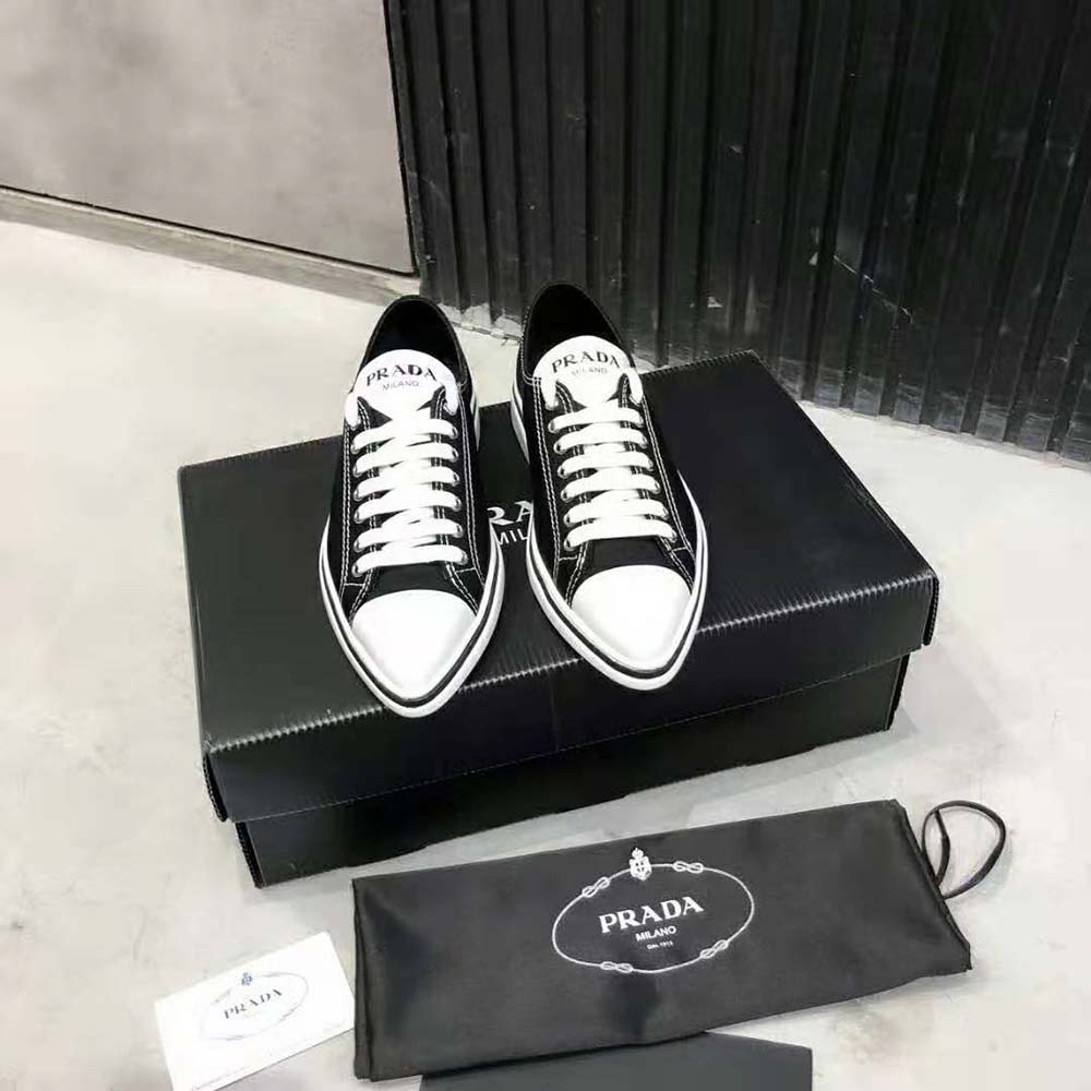 Close-up detail of black leather and Prada logo on synthesis sneakers