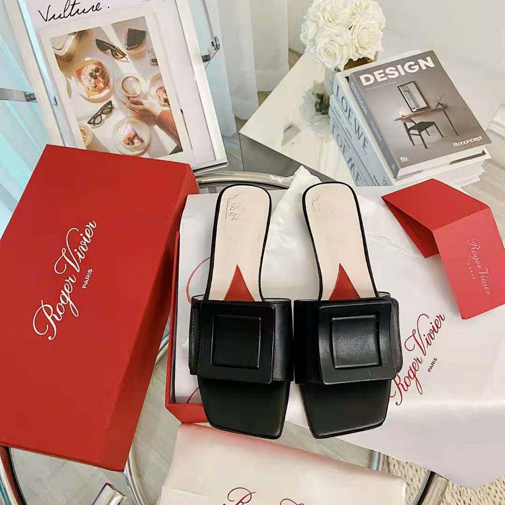 Close-up of the signature covered buckle on Roger Vivier black patent mules