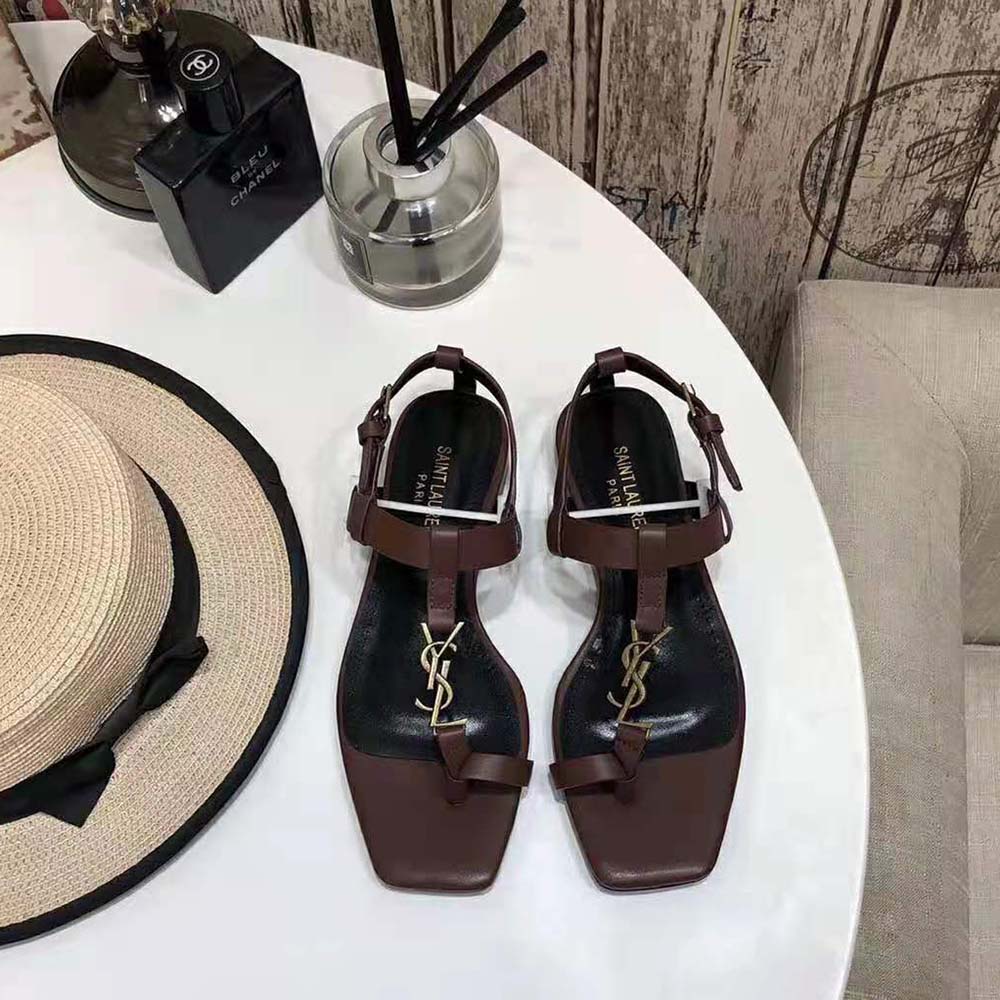Close-up of gold-tone YSL monogram on Cassandra Flat Sandals