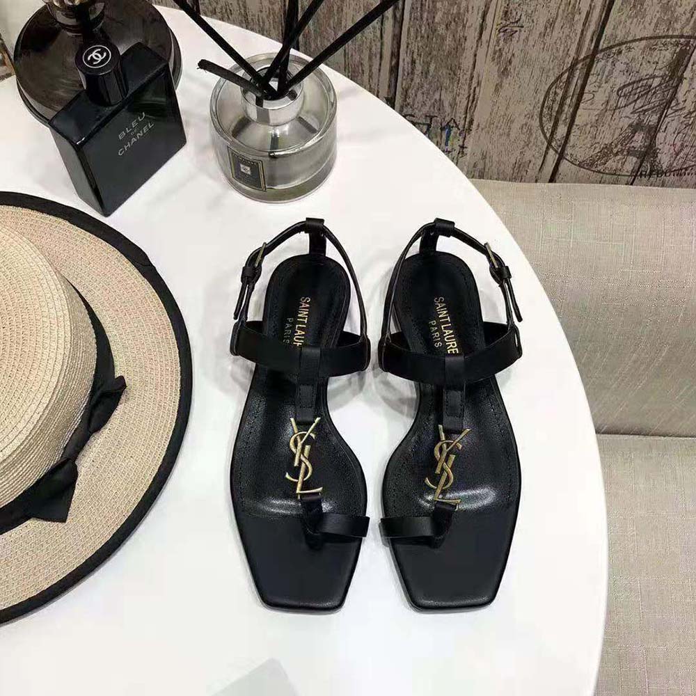 Close-up of gold-tone YSL monogram on Cassandra Flat Sandals