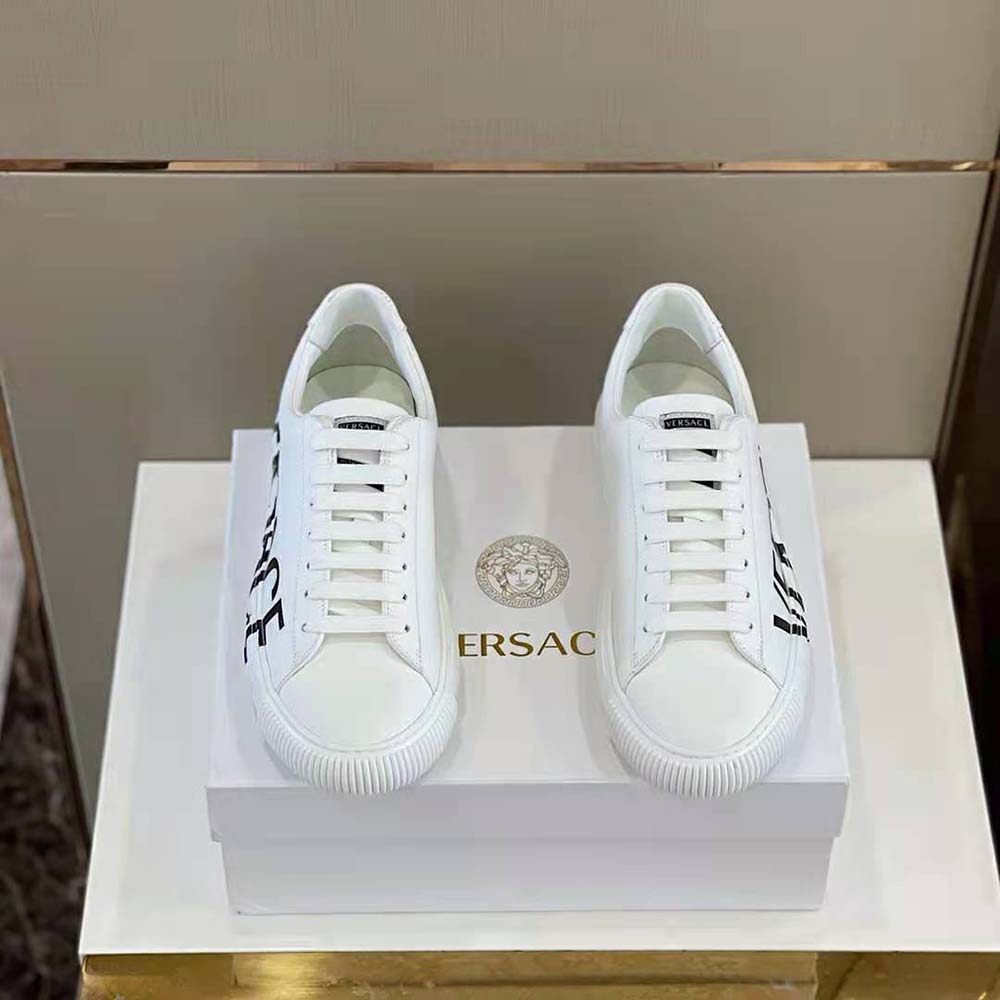 Close-up of gold Greca logo hardware on Versace Unisex Shoes Greca Logo Sneakers-White