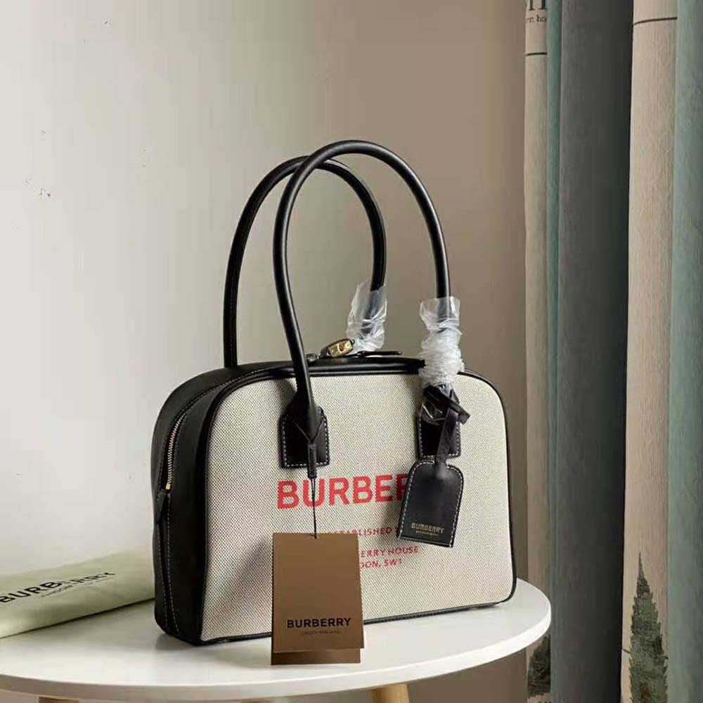 Side angle showing gold-tone hardware and zip closure on Burberry bag