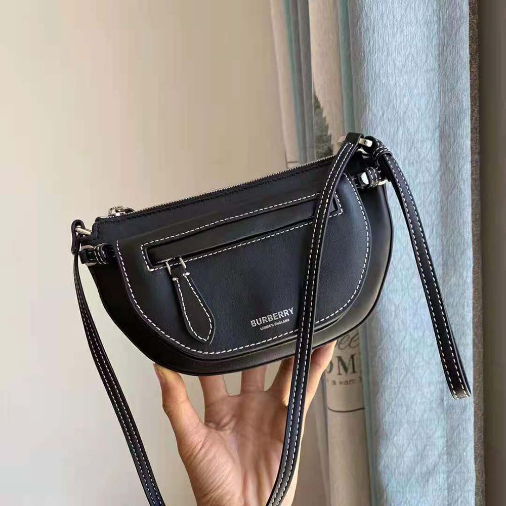 Close-up on gold-tone double Olympia clasp of Burberry Women Mini Leather Double Olympia Bag-Black