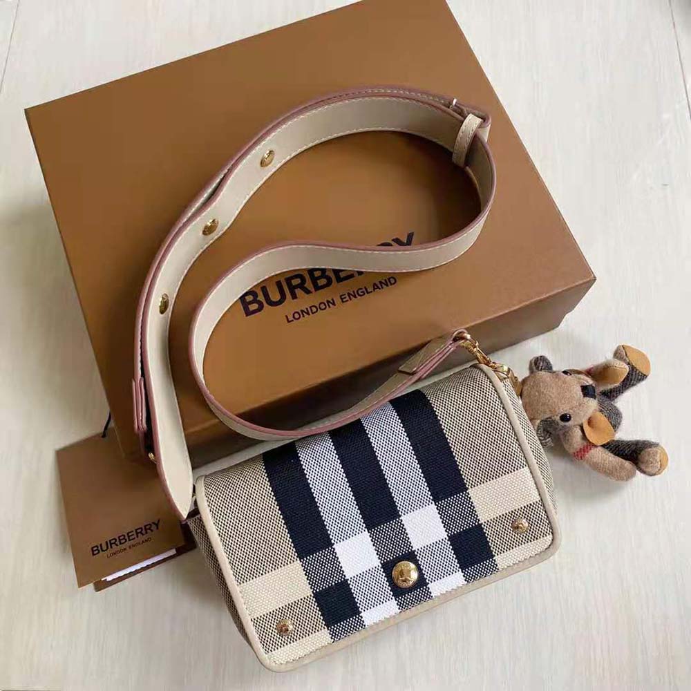 Close-up of Burberry logo and gold hardware on canvas bag