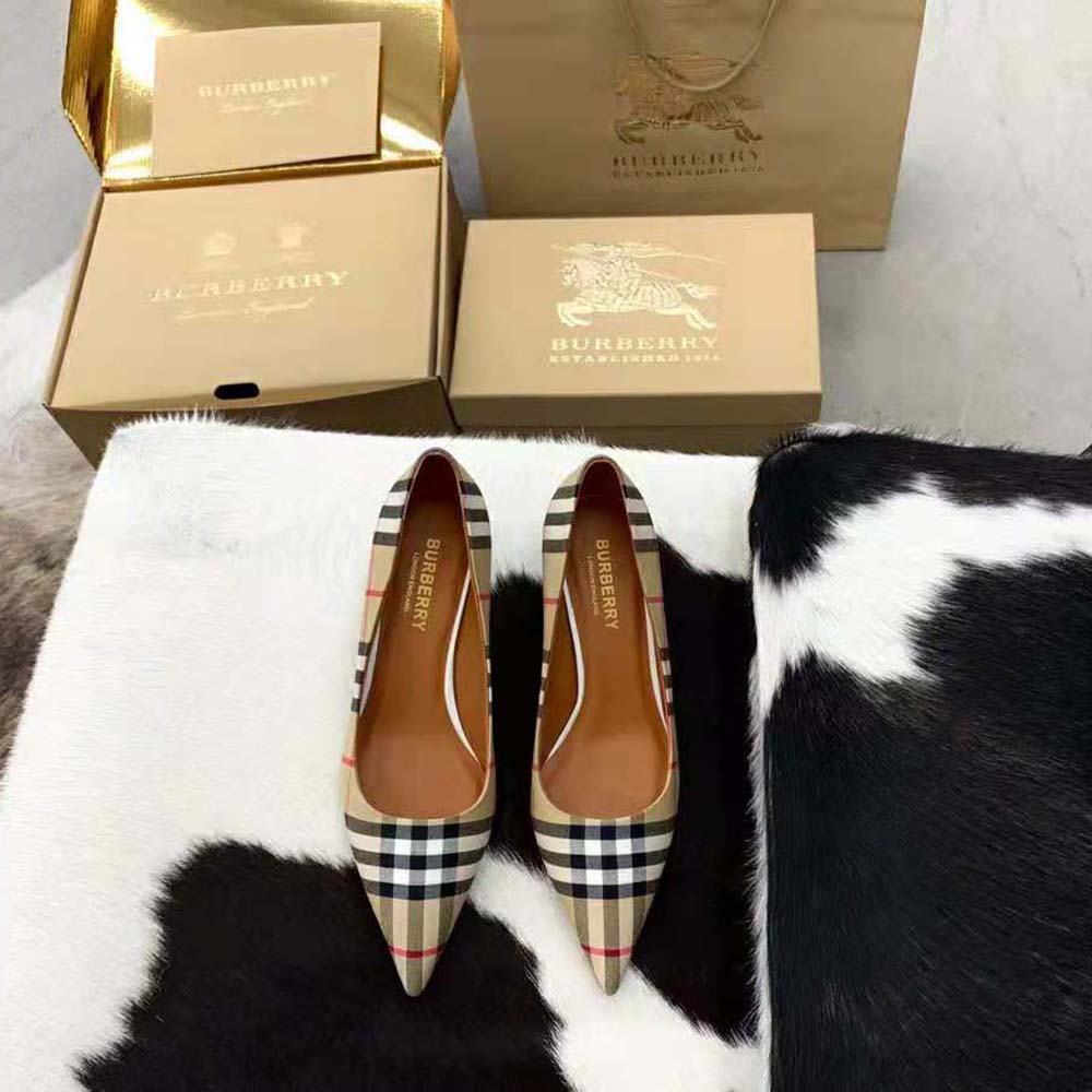 Close-up of Burberry logo hardware on brown cotton pumps heel