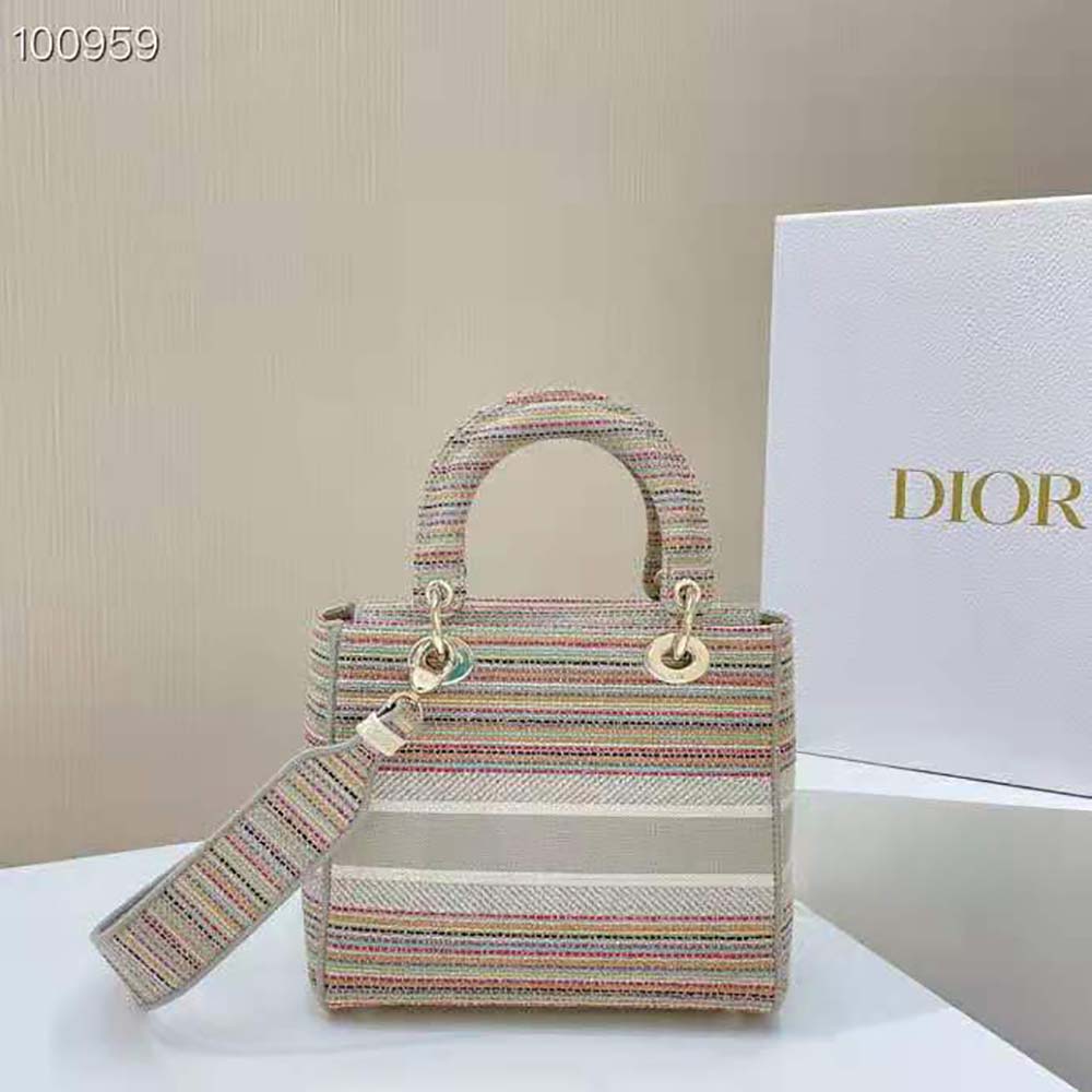Side angle showing pink canvas and magnetic closure of Dior Lady D-lite Bag