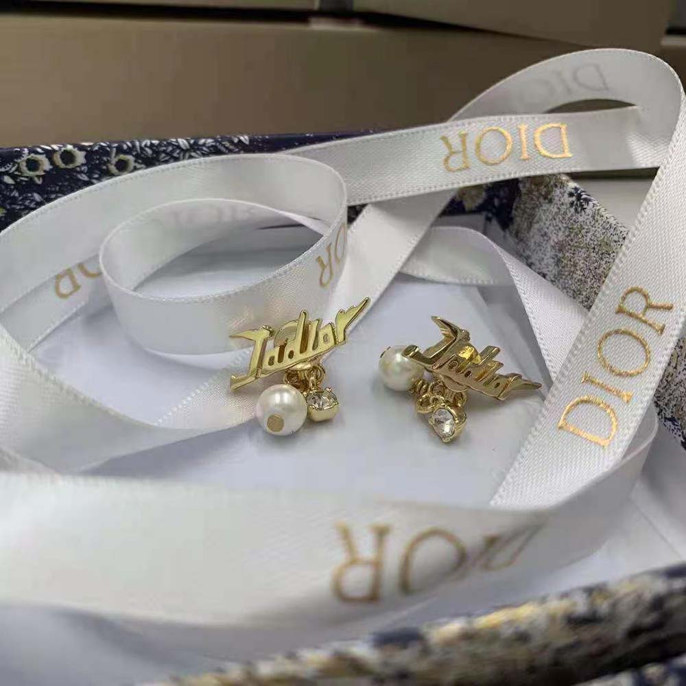 Detail of polished gold-finish metal and white resin pearls, Dior Women Tribales Earrings