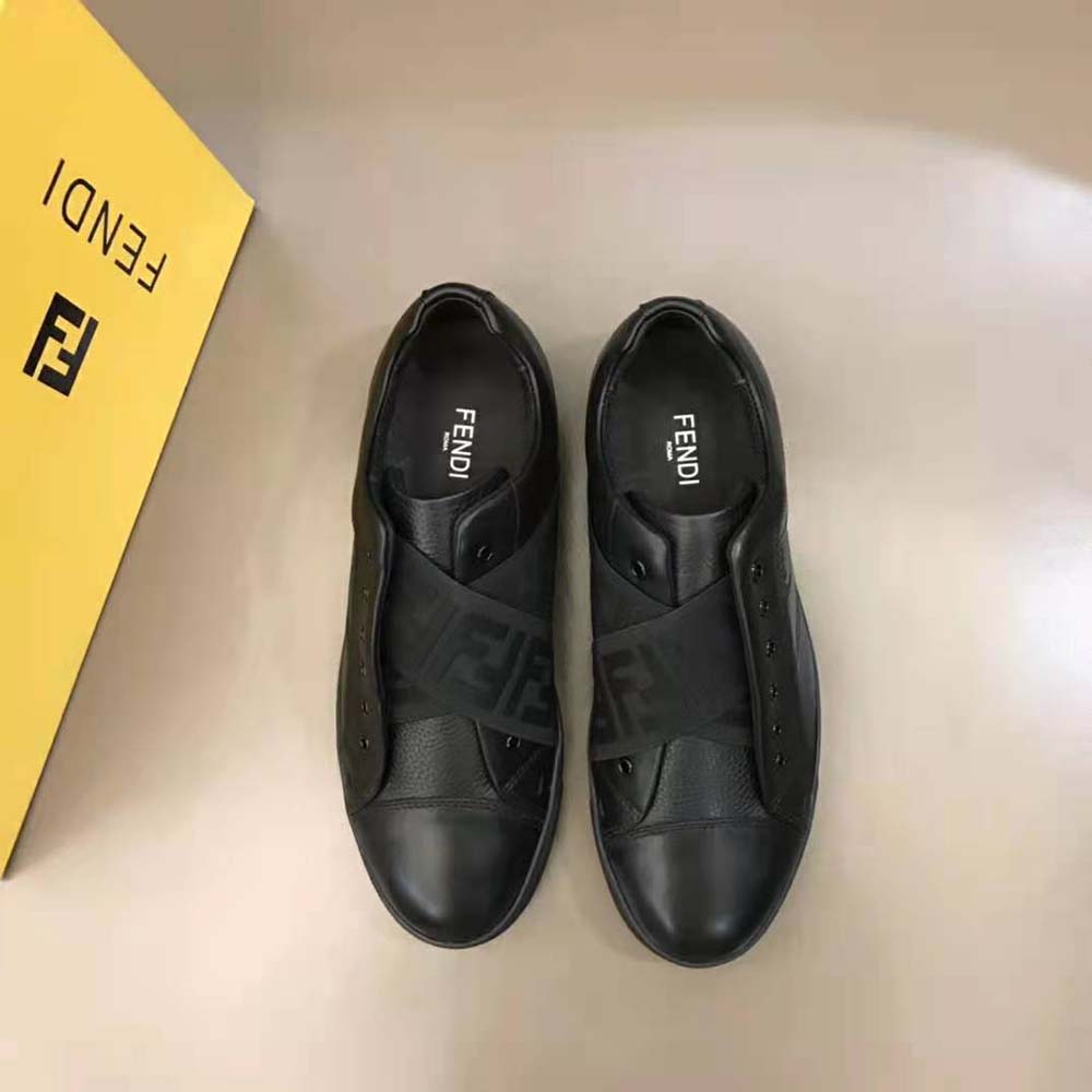 Close-up of Fendi logo and black leather texture on sneakers
