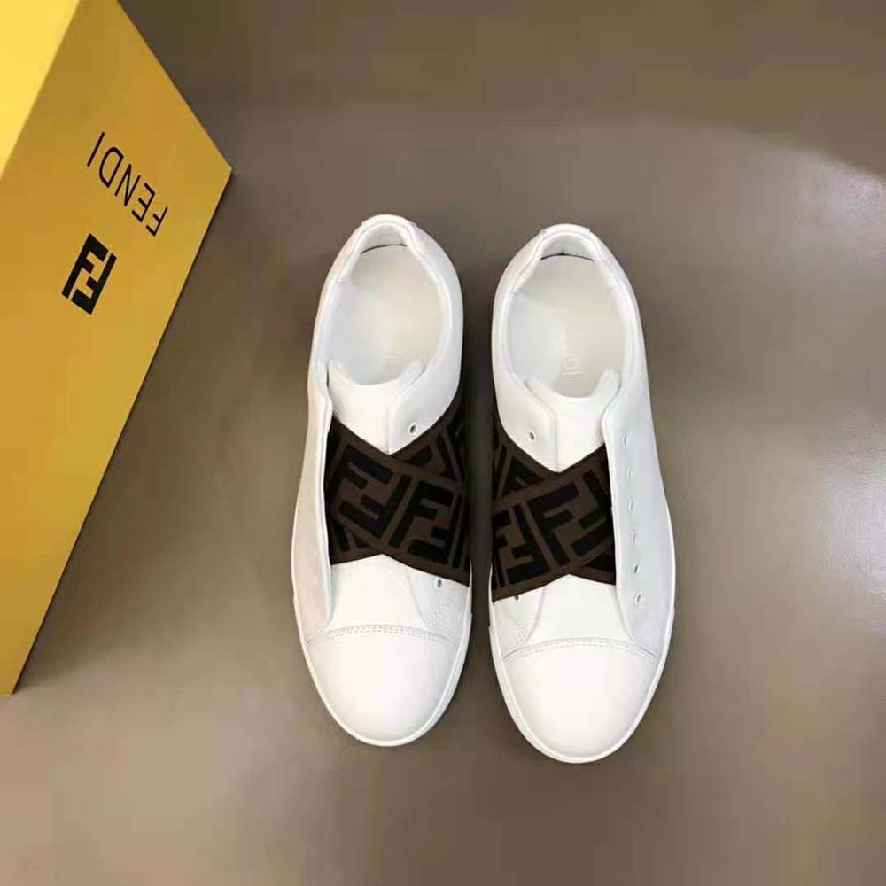 Close-up detail of white leather and Fendi logo on sneakers