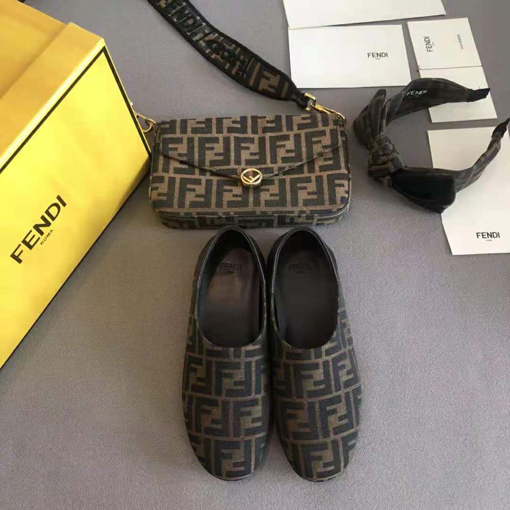 Close-up of Fendi hardware detail on brown fabric slippers