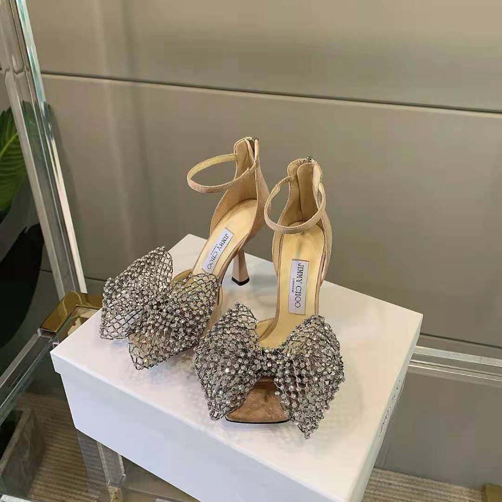Close-up of crystal bow clasp on Jimmy Choo Mana 100 pink suede sandals