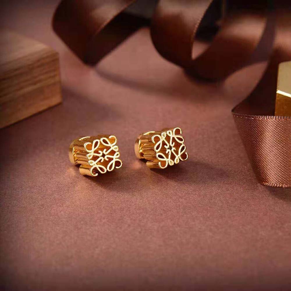 Close-up detail of Loewe Anagram logo on gold metal earrings