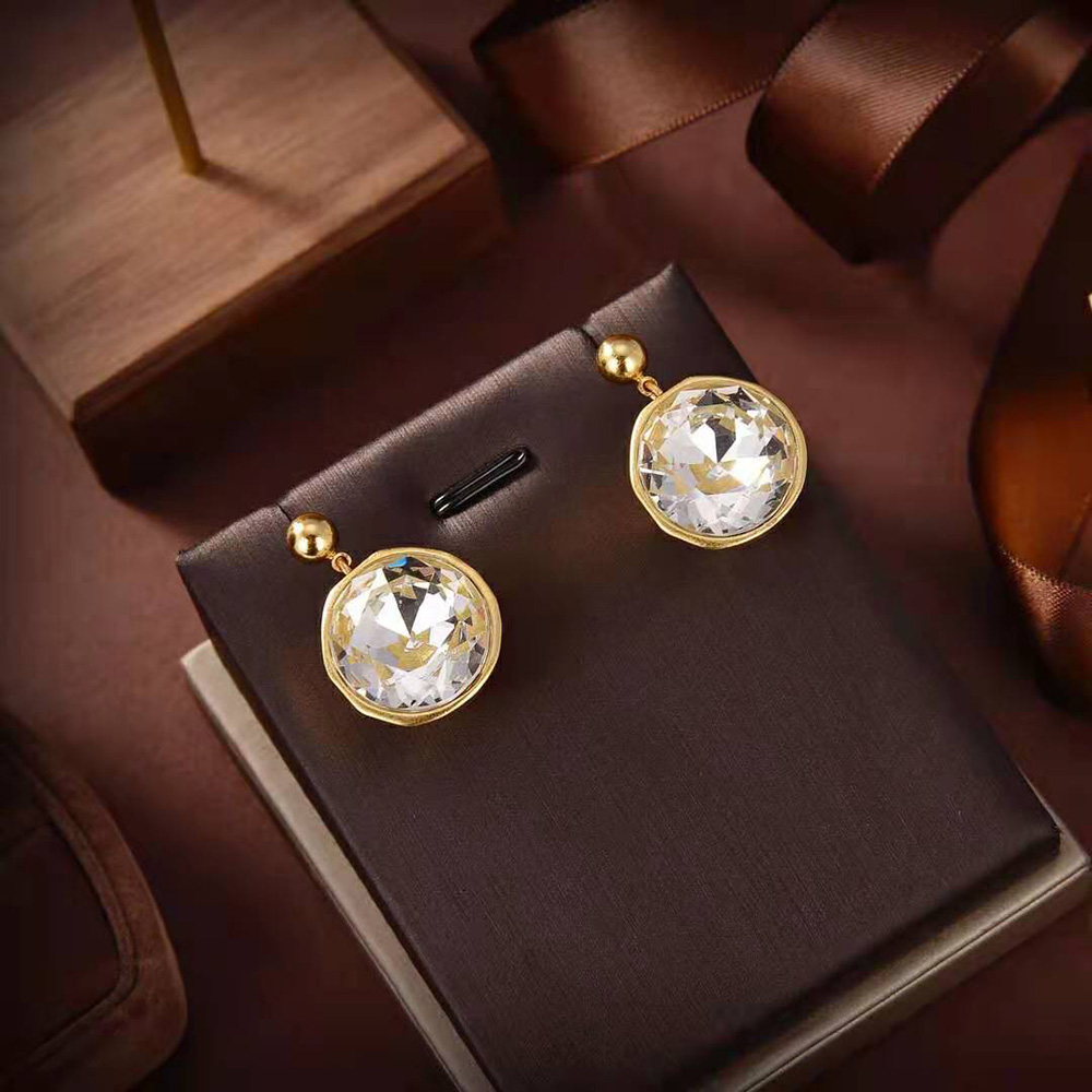 Detail shot of gold metal and crystal facets on Loewe Women Sphere Earrings
