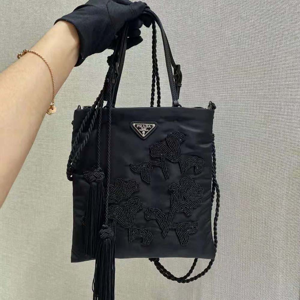 Close-up detail of embroidery and silver hardware on Prada handbag