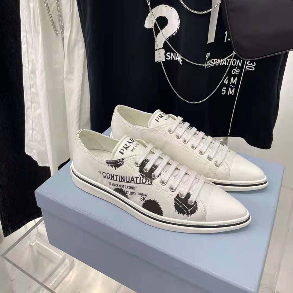 Close-up on lace-up closure and printed fabric detail of Prada sneakers