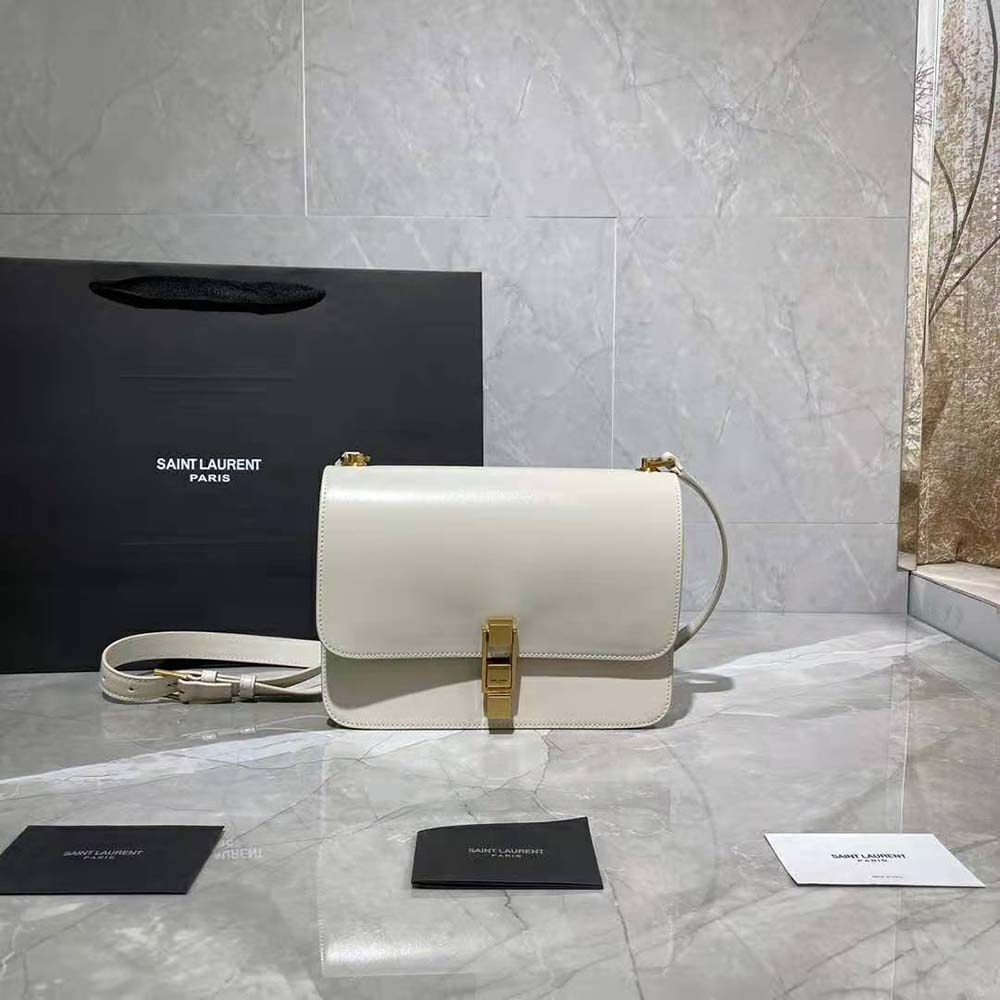 Close-up of gold YSL logo hardware on white LE Carre Satchel