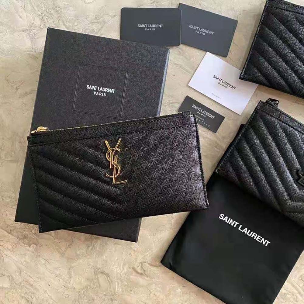 Close-up of gold YSL monogram hardware on bill pouch in embossed leather