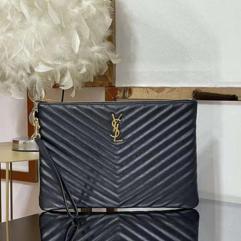 Close-up detail of gold YSL monogram hardware on black document holder