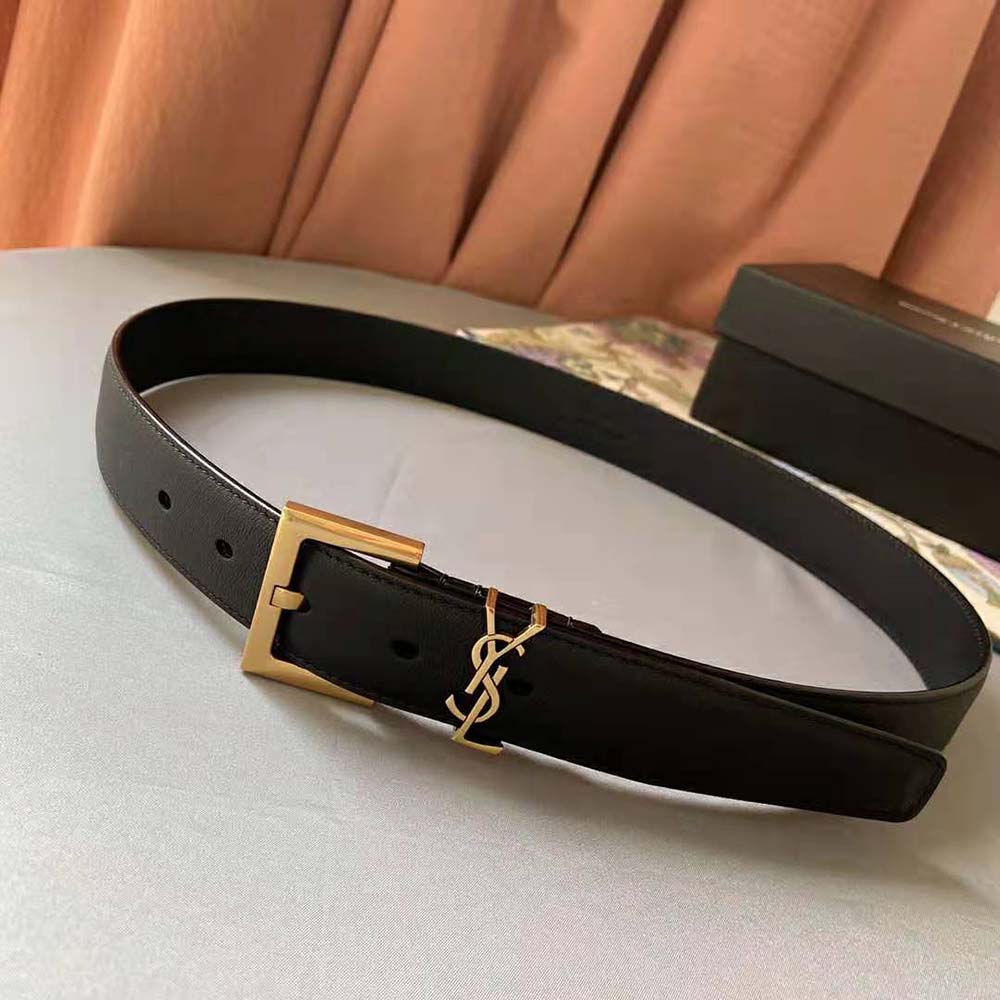 Close-up detail of lacquered leather and YSL square buckle on belt