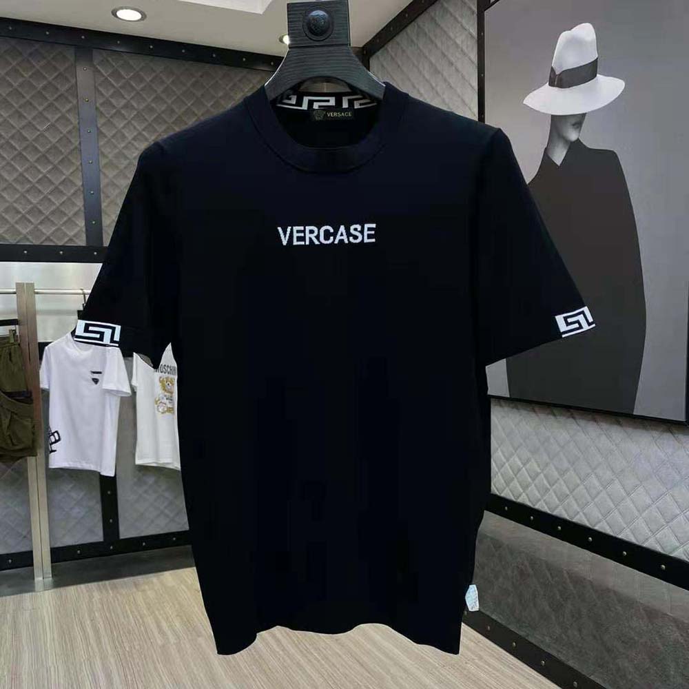 Close-up of embroidered Versace logo on black t-shirt fabric
