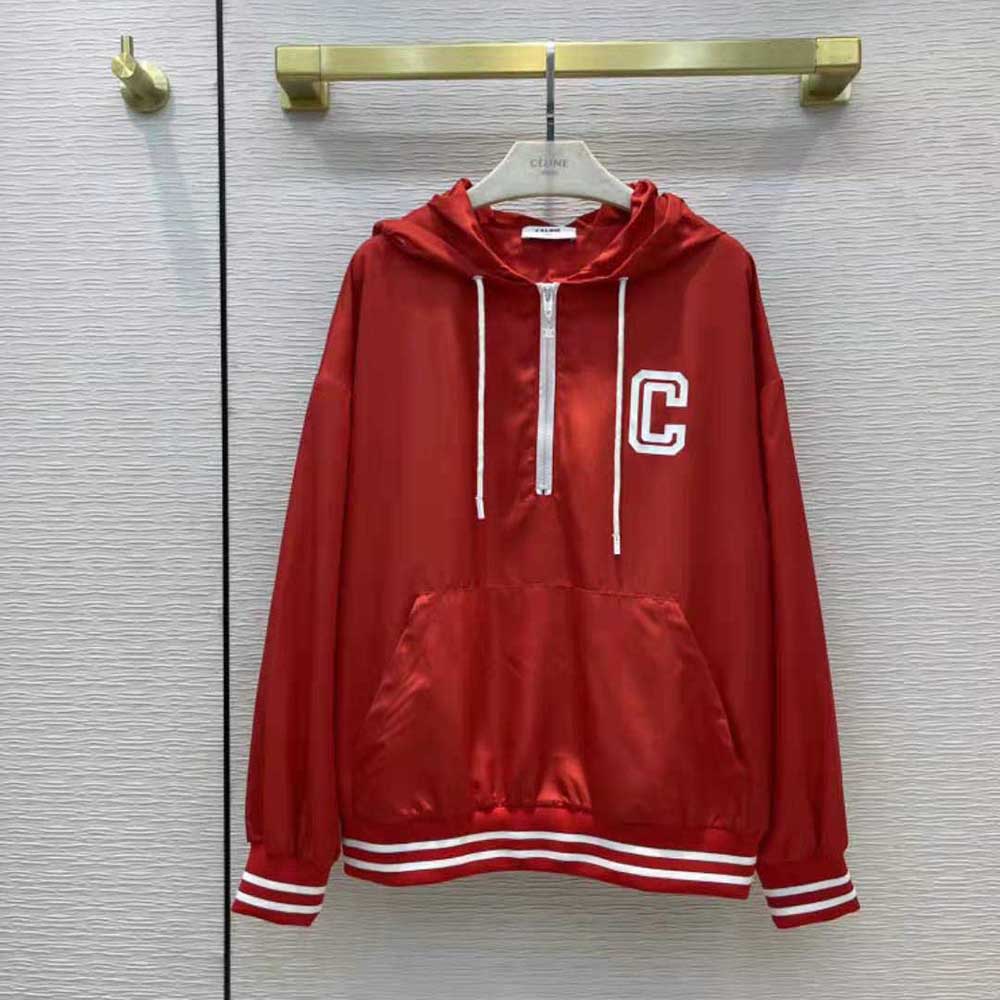 Close-up detail of Celine logo hardware on red nylon windbreaker zipper